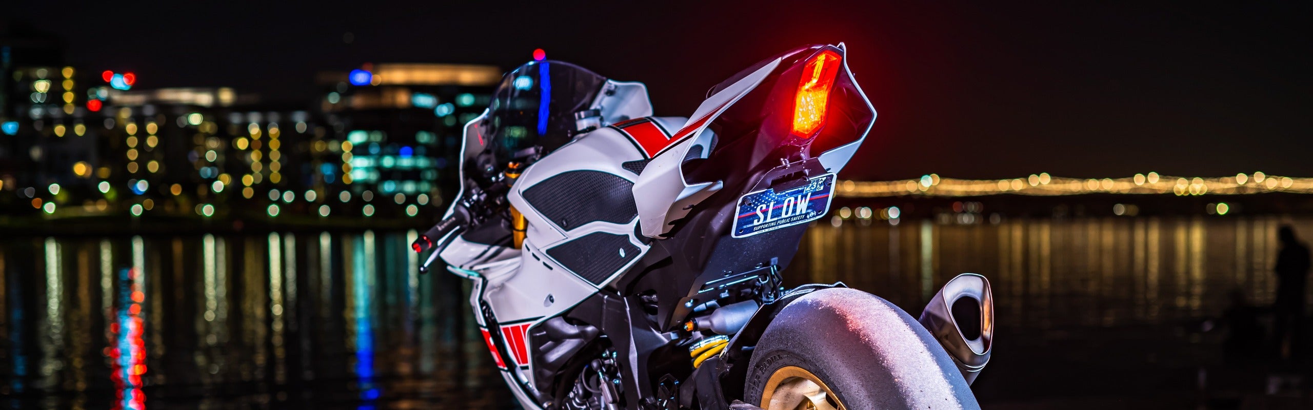 Moto sportive blanche de nuit avec kit fender eliminator, feu arrière LED intégré et support de plaque furtif